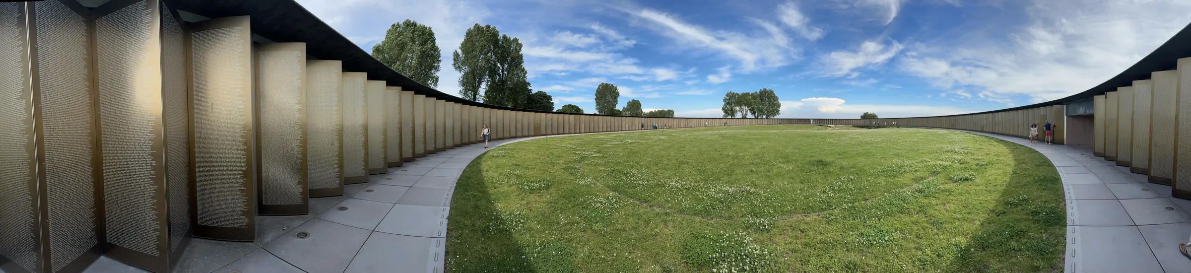 Vue panoramique de l'intérieur de l'Anneau de la Mémoire : la pelouse centrale et les panneaux de noms